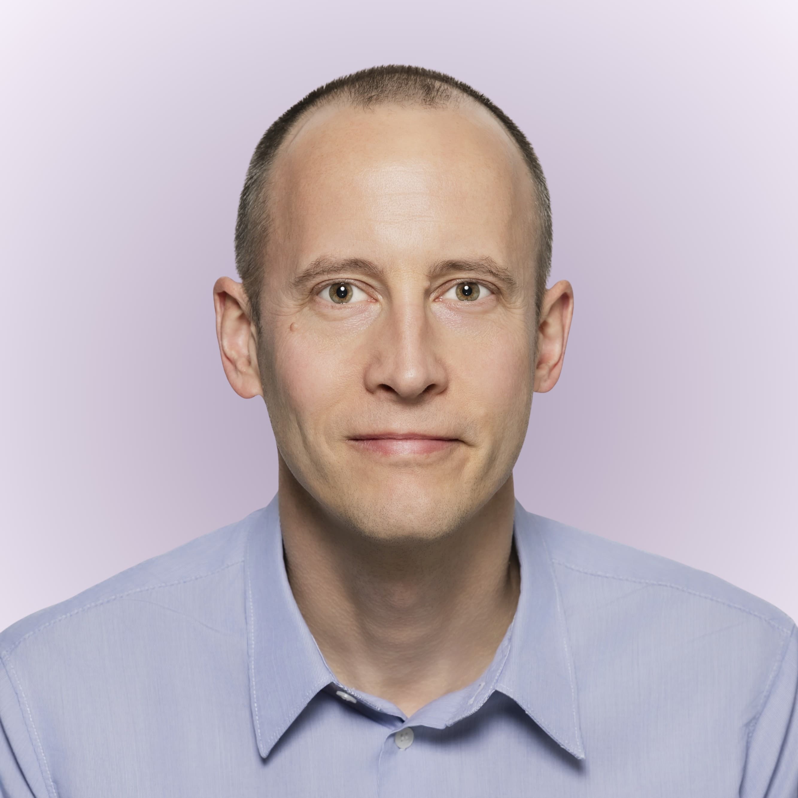 Christophe Coupé, a smiling man with short brown hair and glasses, wearing a white shirt
